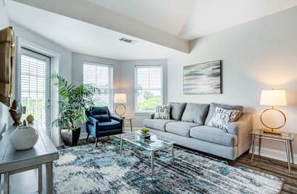 a living room with a couch and a chair and a glass coffee table