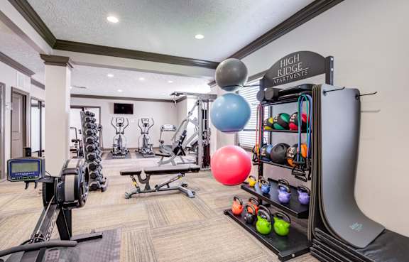 our apartments showcase a gym with equipment and a flat screen tv at High Ridge Apartments in Georgia, 30606