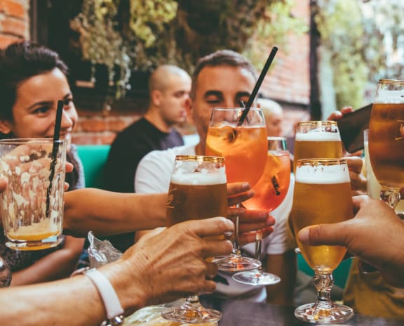 a group of people holding up glasses of beer