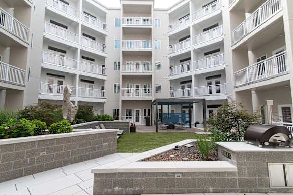 Apartment complex with a courtyard and a sculpture.