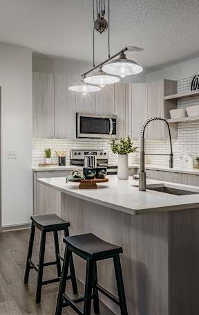 A kitchen with a white countertop and a stainless steel refrigerator.