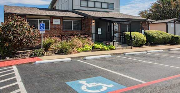 A parking lot with a handicap parking sign painted on the pavement.