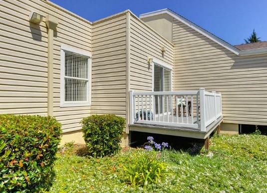 Private Patio with Grass, Bushes and Building Exterior at Vineyard Terrace Apartments, Napa, CA