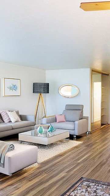 A modern living room with a blue refrigerator and a dining table set for two.