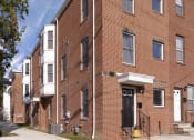Thumbnail 1 of 4 - a red brick apartment building with a yellow fire hydrant