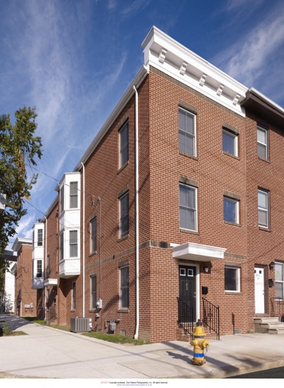 a red brick apartment building with a yellow fire hydrant