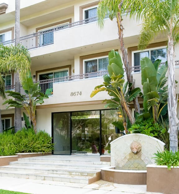 an apartment building with a fountain in front of it