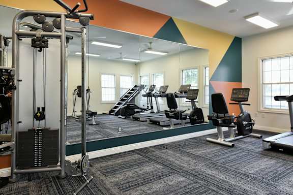 a room filled with lots of exercise equipment and a large mirror