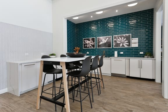 a dining area with a white table and black chairs
