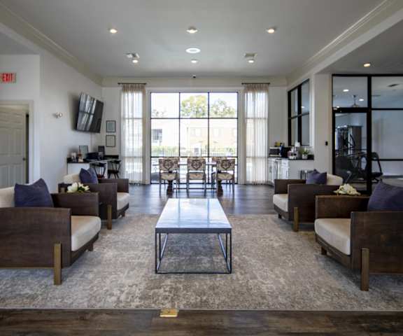 A spacious living room with a central coffee table and multiple seating options.