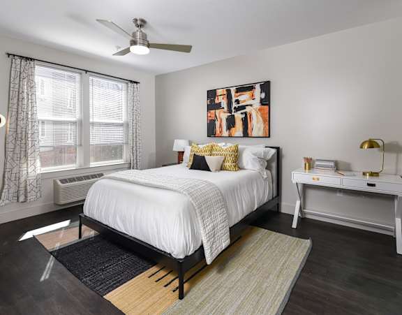 A bedroom with a bed, nightstand, and window.