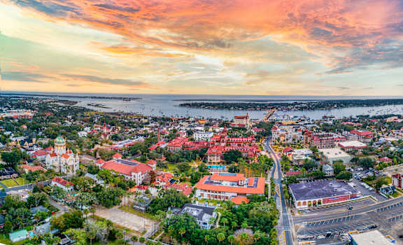 A beautiful aerial view of a town with buildings and a body of water in the distance.