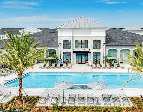 A large white building with a pool in front.