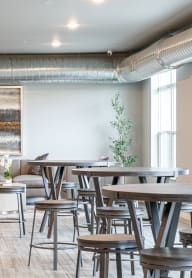 a communal area with stools and tables in the lobby of an office building
