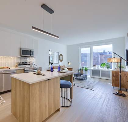 A modern kitchen with wooden cabinets and a bar stool.