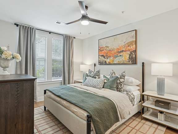 A bedroom with a bed, a dresser, and a painting on the wall.
