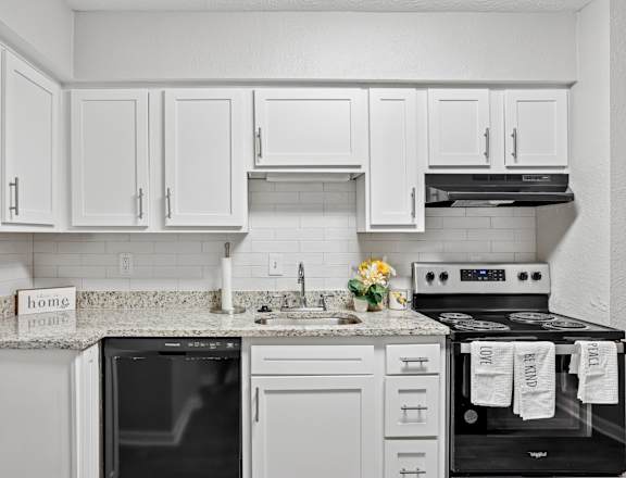 A kitchen with white cabinets and appliances.at Magnolia at Whitlock, Georgia