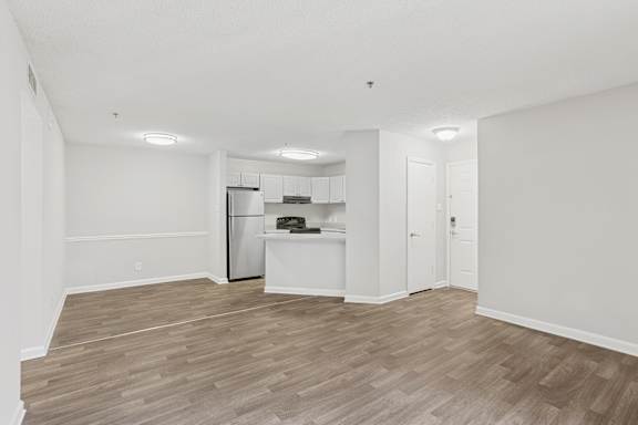 A kitchen with a refrigerator, oven, and cabinets.