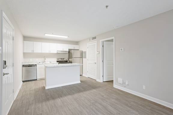 A kitchen with white appliances and a white island in the middle of the room.