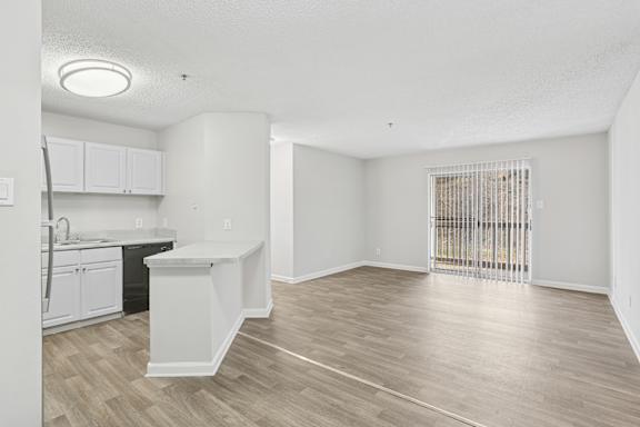 A kitchen with white cabinets and a black countertop is shown.