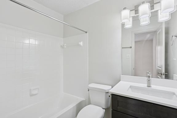 A white bathroom with a toilet, sink, and bathtub.