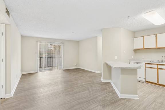A spacious room with a white counter and wooden flooring.