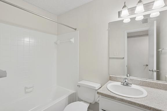 A white bathroom with a sink, toilet, and bathtub.