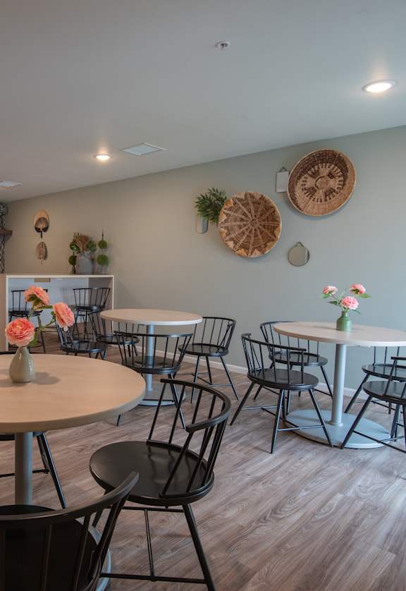 a dining room with tables and chairs and a kitchen