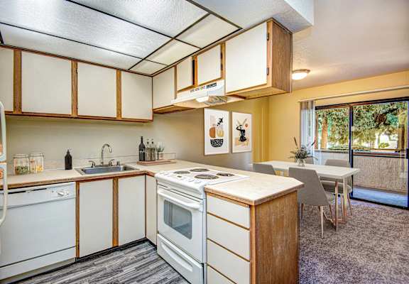a kitchen with a stove and a sink and a table at Autumn Village, Washington