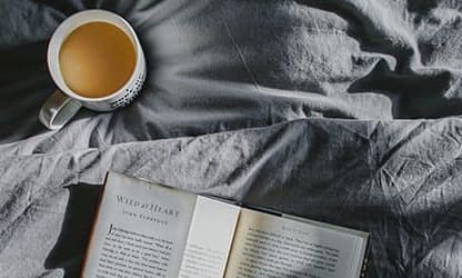 Coffee and book on bed
