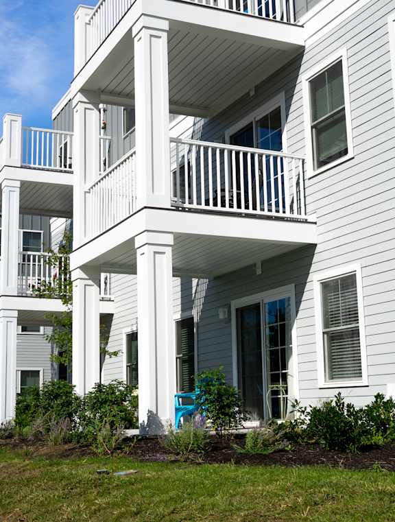 a view of the back of a white house with balconies