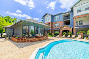 A swimming pool in a backyard with a building in the background.