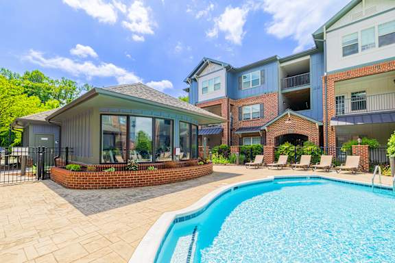 A swimming pool in a backyard with a building in the background.