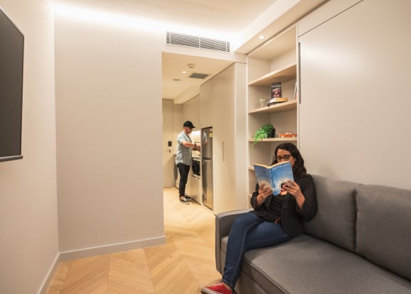 a woman sitting on a couch reading a book
