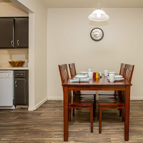 A dining room with a wooden table and chairs.
