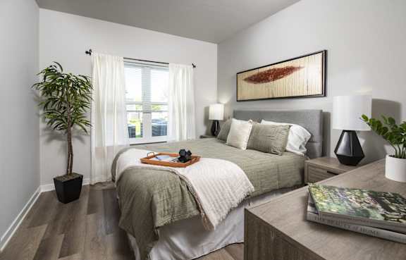 a bedroom with a large bed and a potted plant