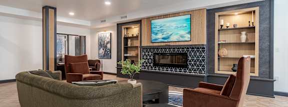 A modern living room with a green sofa and a fireplace.