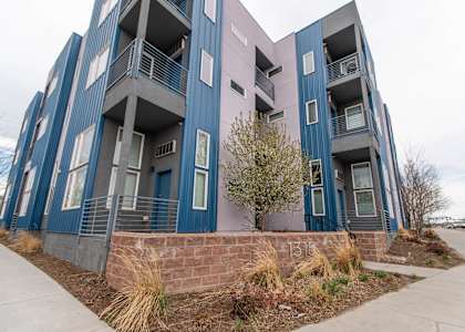 A modern apartment building with blue and pink balconies.