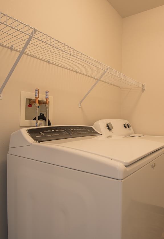 A white washing machine in a laundry room.
