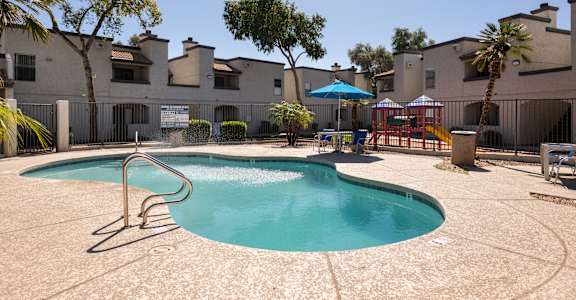 A swimming pool in a courtyard surrounded by buildings.