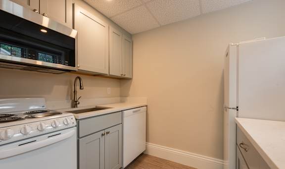 A kitchen with white appliances and cabinets.