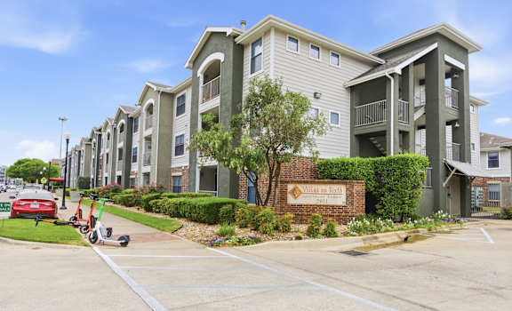 A row of apartment buildings with a sign that says "Villages at Hillcrest".