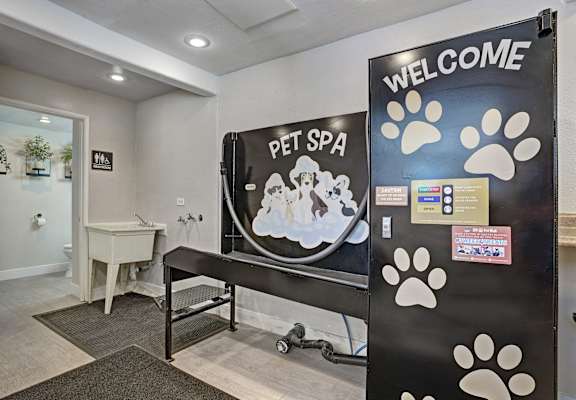 A pet spa with a sign that says "Welcome" and a picture of a dog and cat.
