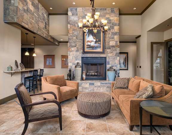 A living room with a stone fireplace and a painting above it.