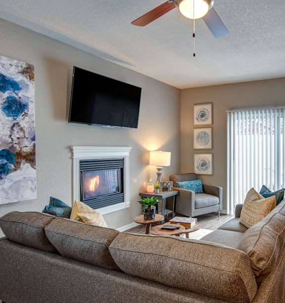 A living room with a grey couch and a wooden table.