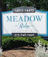 A sign for Meadow Ridge Apartments with a phone number on it.