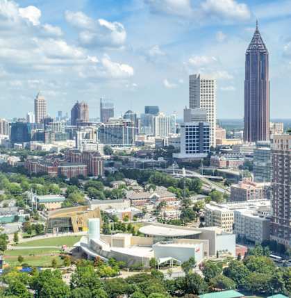 A cityscape with a mix of modern and older buildings, with a tall tower in the center at Gardens at Washington Park in Atlanta, GA, 30314
