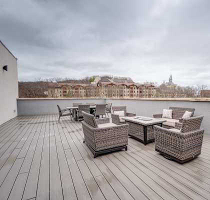 the deck has a view of the river and a patio with chairs and tables