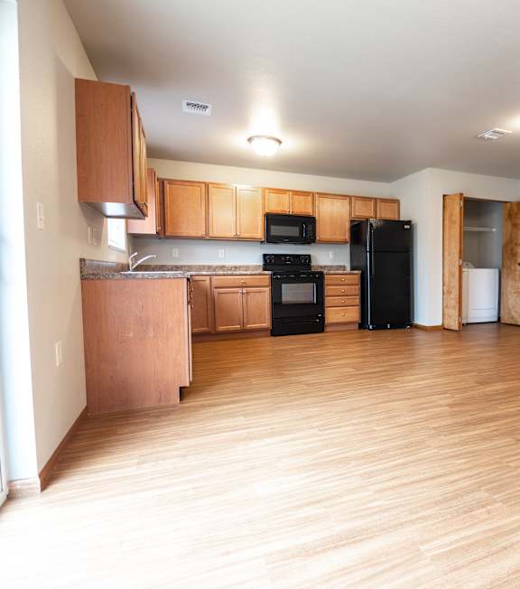 A kitchen with wooden floors and cabinets.