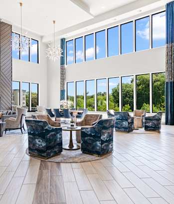 A large, modern lobby with a stone pillar and a circular table in the center.